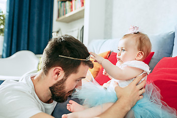 Image showing Proud father holding his baby daughter at home