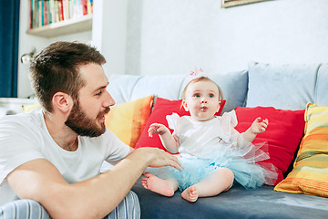 Image showing Proud father holding his baby daughter at home