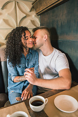 Image showing Happy young couple is drinking coffee and smiling while sitting at the cafe