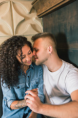 Image showing Happy young couple is drinking coffee and smiling while sitting at the cafe