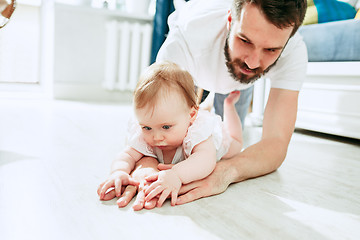 Image showing father and his baby daughter at home