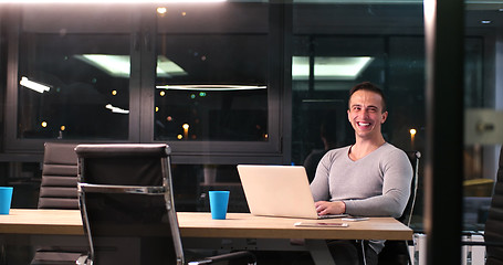 Image showing man working on laptop in dark office