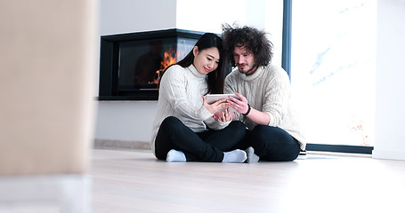 Image showing Young Couple using digital tablet on the floor