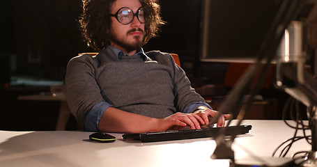 Image showing man working on computer in dark office