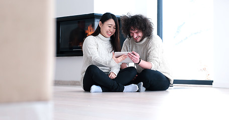 Image showing Young Couple using digital tablet on the floor