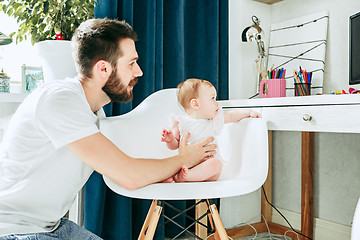 Image showing father and his baby daughter at home