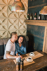 Image showing Happy young couple is drinking coffee and smiling while sitting at the cafe