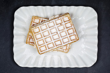 Image showing Belgium waffers with sugar powder on ceramic plateon black board