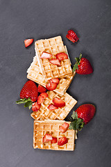 Image showing Belgium waffers with strawberries on black board background.