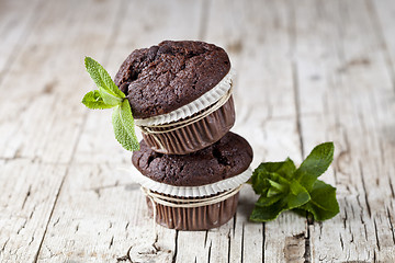 Image showing Chocolate dark muffins with mint leaves.