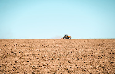 Image showing Tractor plowing the land in a spring field