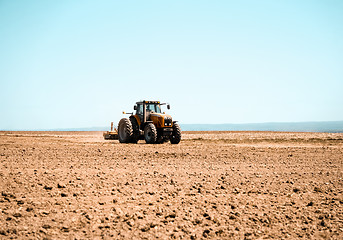 Image showing Tractor plowing the land in spring