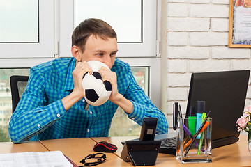 Image showing An office worker watches football in the workplace