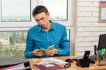 Image showing Young office worker counting money