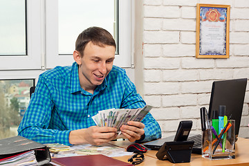 Image showing Accountant counts money at the table in the office