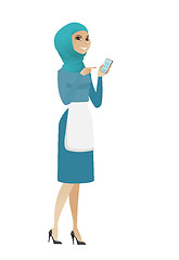 Image showing Young muslim cleaner holding a mobile phone.