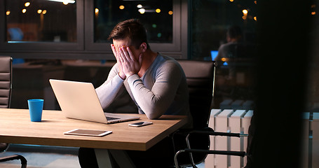 Image showing man working on laptop in dark office