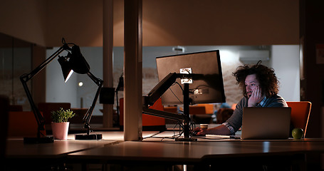 Image showing man working on computer in dark office