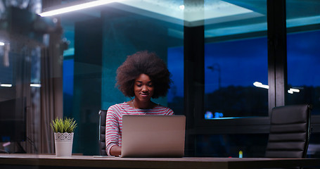 Image showing black businesswoman using a laptop in night startup office