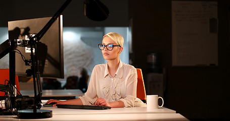 Image showing woman working on computer in dark office