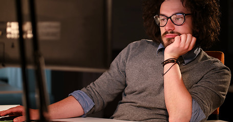 Image showing man working on computer in dark office