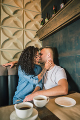 Image showing Happy young couple is drinking coffee and smiling while sitting at the cafe