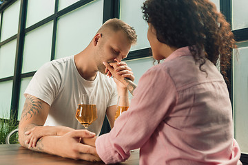 Image showing She said him yes. Closeup of young man kissing his wife hand while making marriage proposal outdoors.