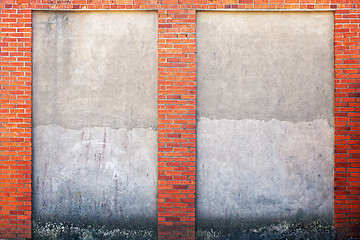 Image showing weathered stucco wall and red brick frame around