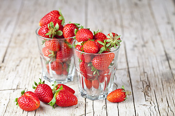 Image showing Organic red strawberries in two glasses on rustic wooden backgro