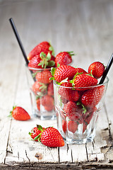 Image showing Organic red strawberries in two glasses on rustic wooden backgro