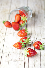 Image showing Organic red strawberries in glass on rustic wooden background.