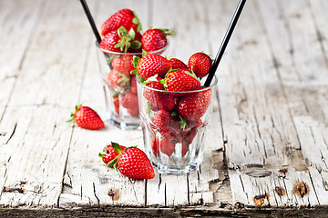 Image showing Organic red strawberries in two glasses on rustic wooden backgro