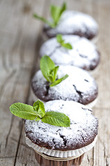 Image showing Fresh chocolate dark muffins with sugar powder and mint leaf on 