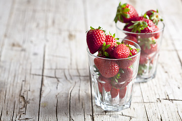 Image showing Organic red strawberries in two glasses on rustic wooden backgro