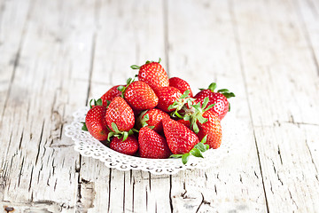 Image showing Organic red strawberries on white plate on rustic wooden backgro