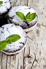 Image showing Fresh chocolate dark muffins with sugar powder and mint leaf on 