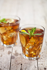 Image showing Two glasses with traditional iced tea with lemon, mint leaves an