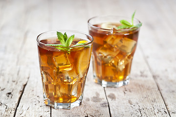 Image showing Two glasses with traditional iced tea with lemon, mint leaves an