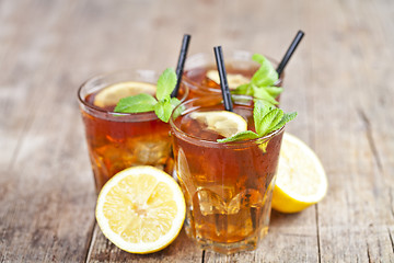 Image showing Ttree glasses of traditional iced tea with lemon, mint leaves an