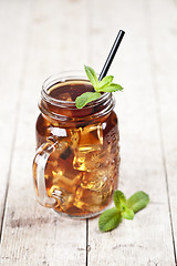 Image showing Traditional iced tea with lemon, mint leaves and ice cubes in gl