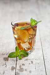 Image showing Traditional iced tea with lemon, mint leaves and ice in glass on