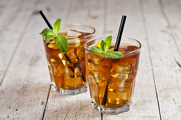 Image showing Traditional iced tea with lemon, mint leaves and ice cubes in tw