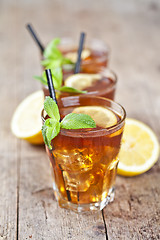 Image showing Traditional iced tea with lemon, mint leaves and ice cubes in th