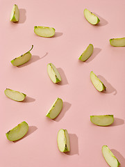 Image showing apple pieces on pink background