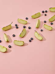 Image showing apple pieces and blueberries on pink background
