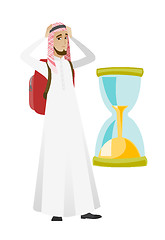 Image showing Worried muslim traveler man looking at hourglass.