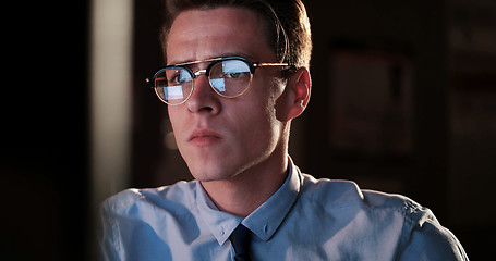 Image showing man working on computer in dark office