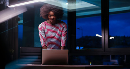 Image showing black businesswoman using a laptop in night startup office