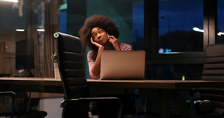 Image showing black businesswoman using a laptop in night startup office