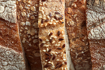 Image showing Crispy organic bread slices with flax seeds and sesame macro photo. Flat lay